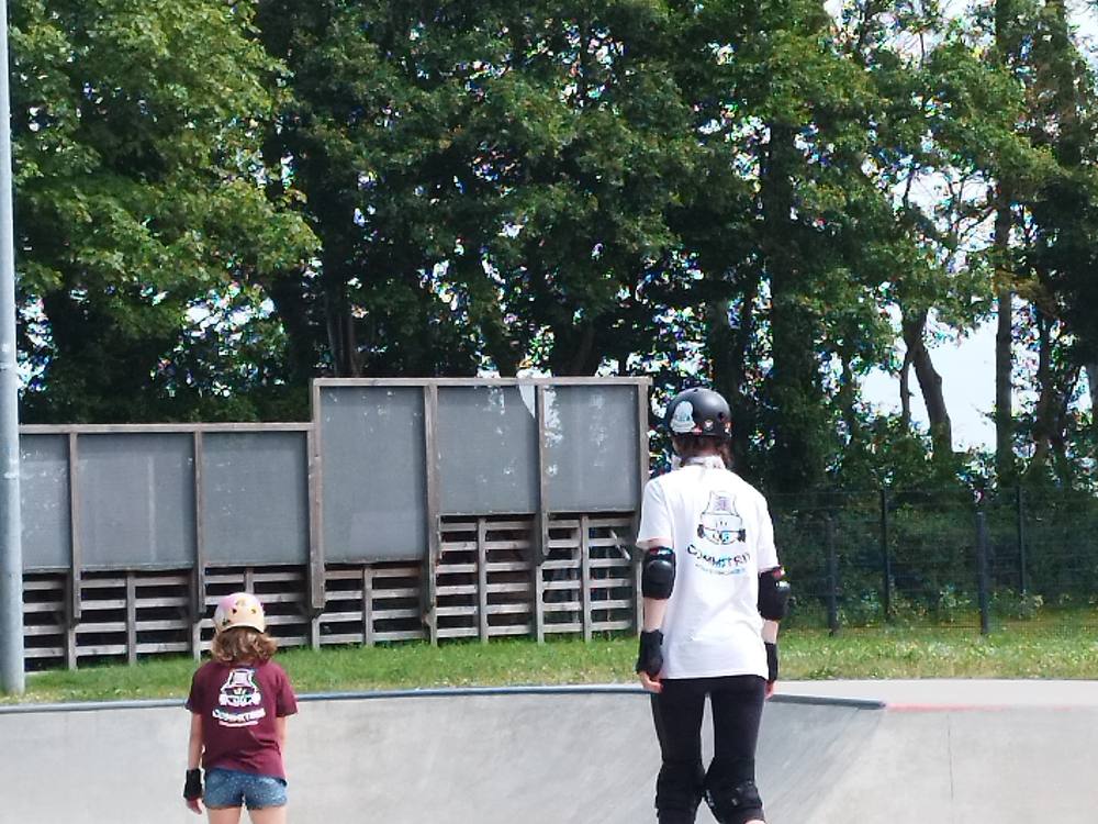 Skaterinnen auf Inlineskates am Rand der Bowl im Skatepark Burg