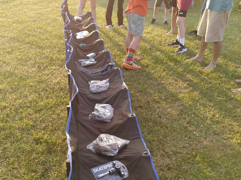 Kinder und Jugendliche stehen vor den ausgelegten SkatePro-Paketen