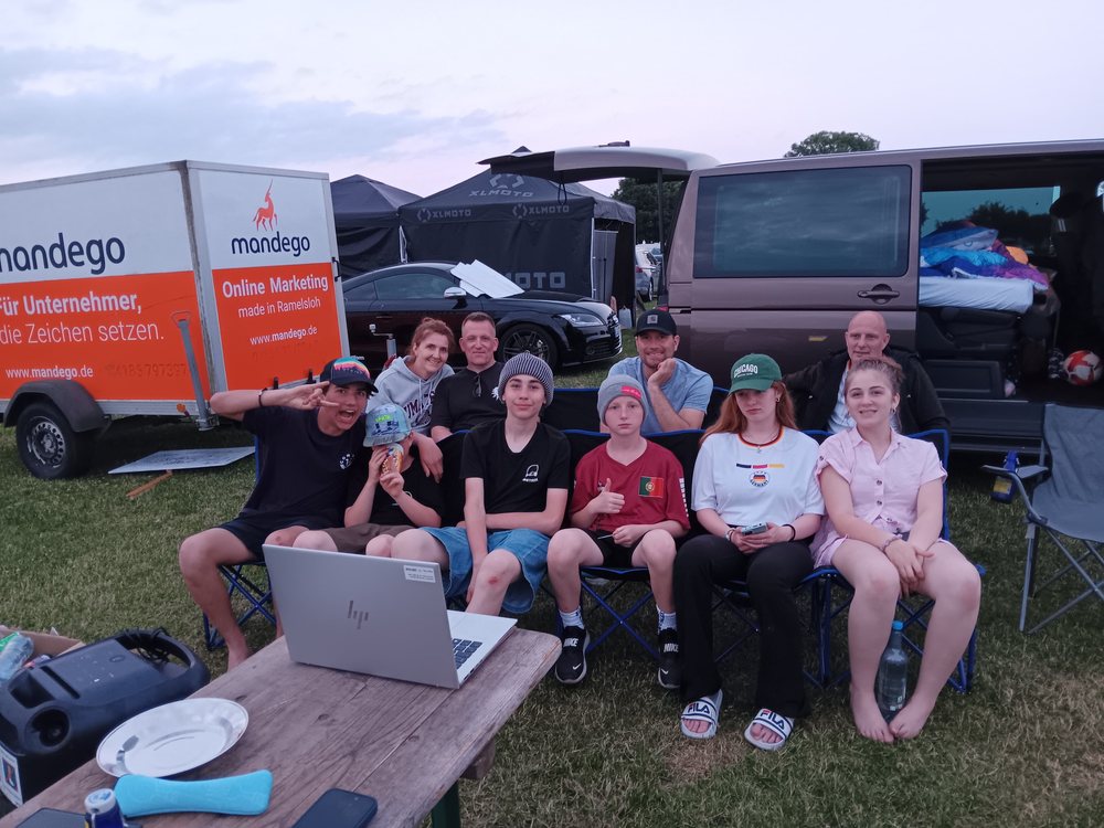 Die Gruppe sitzt vor einem Laptop und schaut gemeinsam WM-Fußball