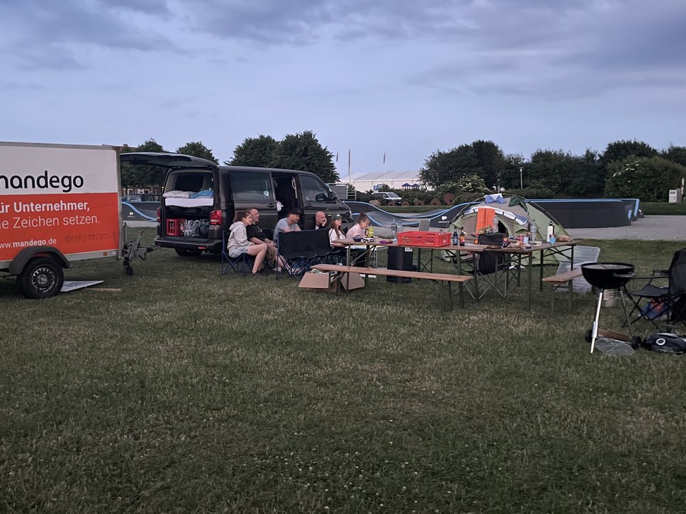 Das Camp am Abend mit Anhänger, Bus und Campingstühlen