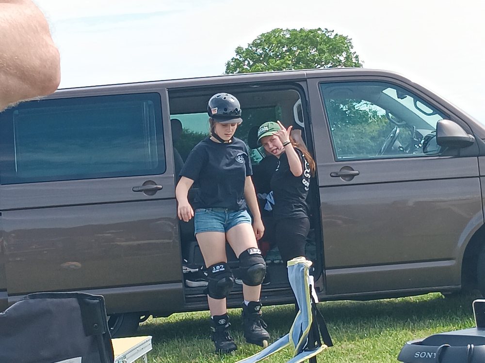 Zwei Jugendliche ziehen am Bus ihre Skates an